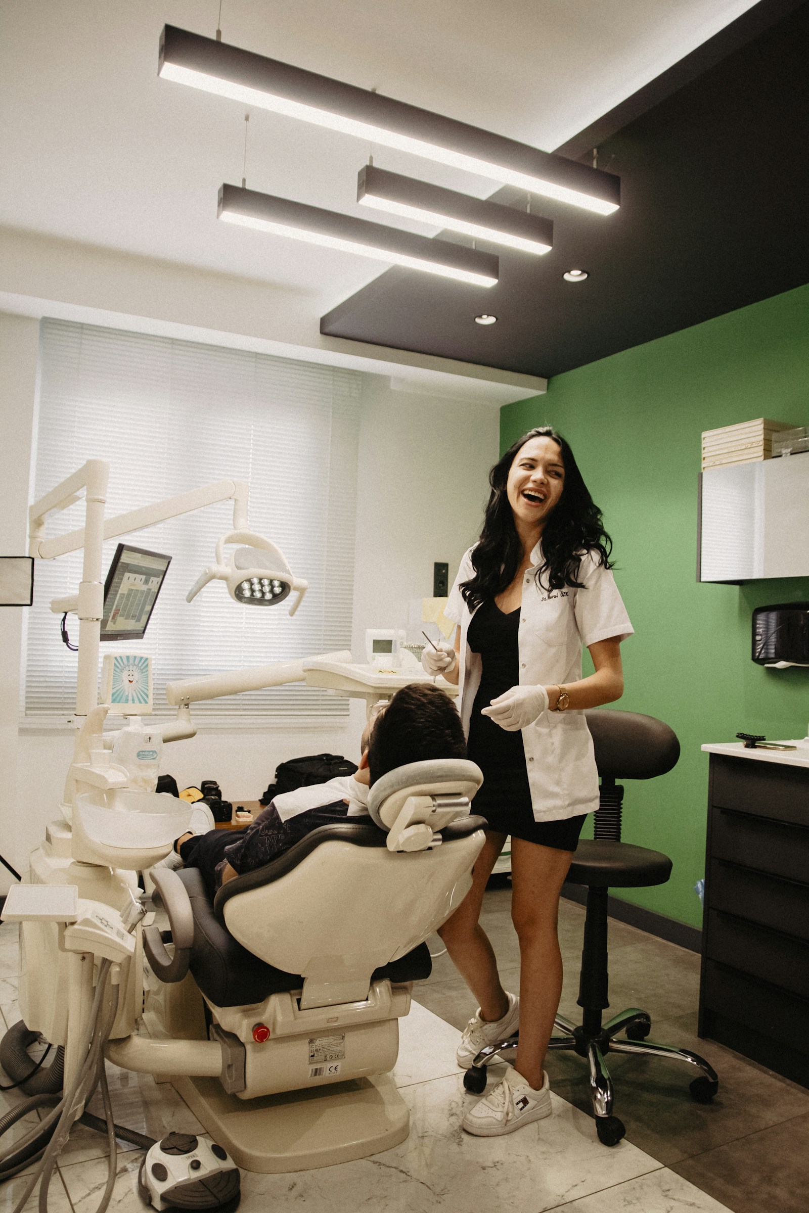 Dentista sorrindo para paciente durante atendimento
