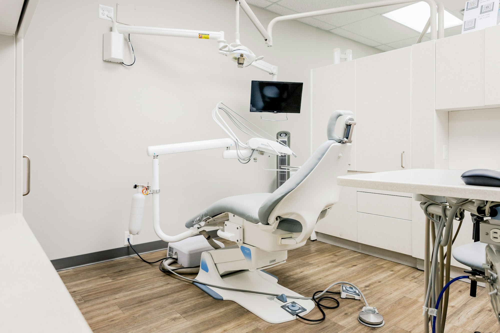Consultório da clínica com cadeira odontológica e janela ampla
