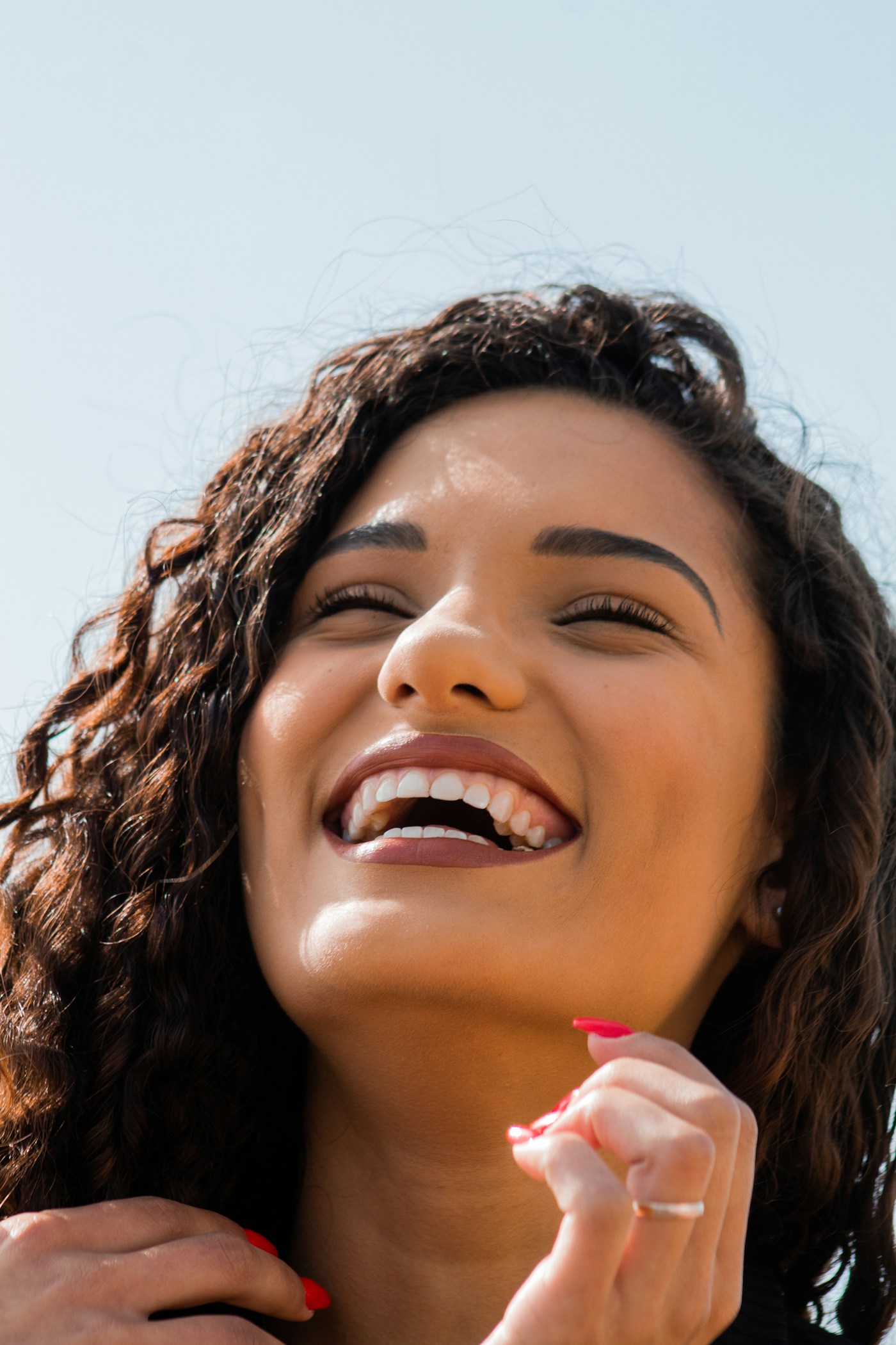 Mulher sorrindo de olhos fechados