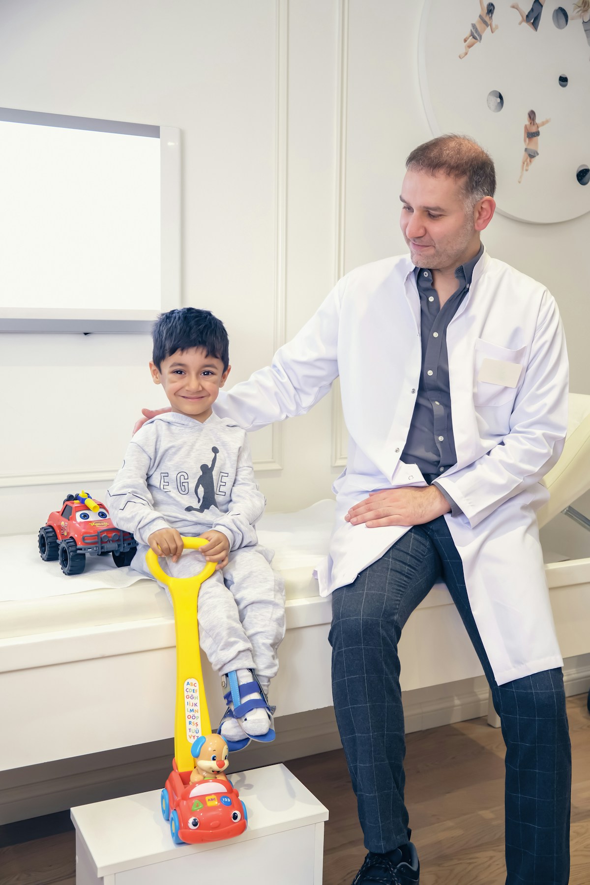 Menino sorrindo ao lado do dentista no consultório